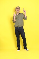 Poster - The 40s adult Asian man with casual dressed standing on the yellow background.