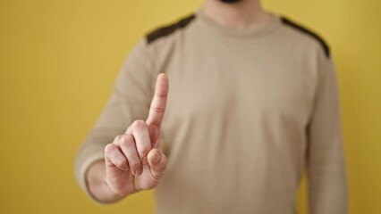 Poster - Young arab man saying no with finger over isolated yellow background