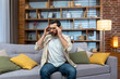 © Liubomir - Headache of mature single man sitting on sofa alone at home and holding head with hands in living room.