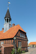 Das alte Rathaus von Ebeltoft, Djursland, Dänemark aus Fachwerk, rotem Backstein und mit Turm in der Sonne vor blauem Himmel