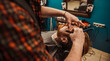 © sergo321 - A professional barber cuts his beard to a young hipster man.