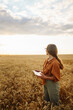 © maxbelchenko - Young Female farmer with tablet in the field. Agriculture, gardening, business or ecology concept. Growth dynamics.