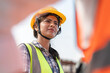 © Supachai - Confident female Indian engineer wearing protective helmet and vest working in factory making precast concrete wall for real estate housing.