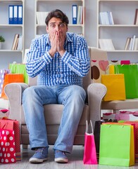 Wall Mural - Young man after excessive shopping at home