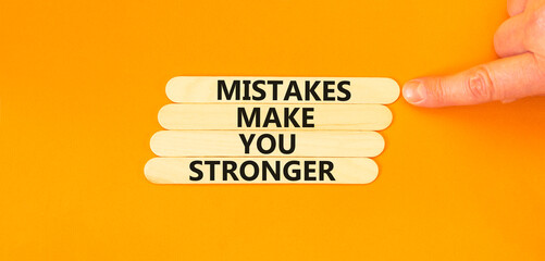 Wall Mural - Mistake make stronger symbol. Concept words Mistakes make you stronger on wooden stick. Beautiful orange table orange background. Businessman hand. Business mistake make stronger concept. Copy space.