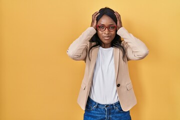 Canvas Print - African young woman wearing glasses suffering from headache desperate and stressed because pain and migraine. hands on head.