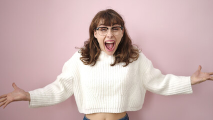 Sticker - Young caucasian woman standing with surprise expression and raised arms over isolated pink background