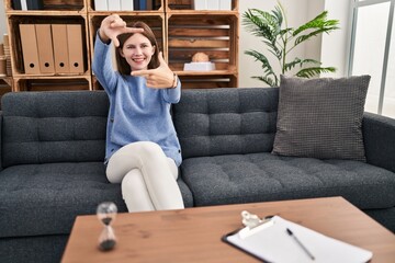 Wall Mural - Young brunette woman at consultation office smiling making frame with hands and fingers with happy face. creativity and photography concept.