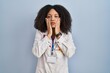Young african american woman wearing doctor uniform and stethoscope tired hands covering face, depression and sadness, upset and irritated for problem