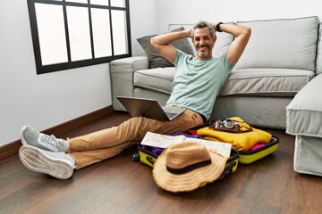 Wall Mural - Middle age grey-haired man using laptop looking for travel at home