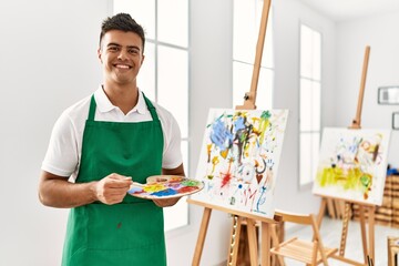 Wall Mural - Young hispanic man smiling confident drawing at art studio