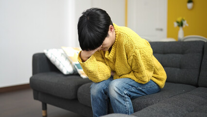 Wall Mural - Young chinese woman suffering for head and stomach ache at home