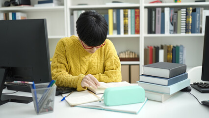 Wall Mural - Young chinese woman student reading book studying at library university