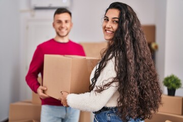 Poster - Man and woman couple holding package at new home