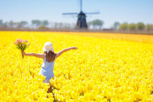 Kids In Tulip Flower Field. Windmill In Holland