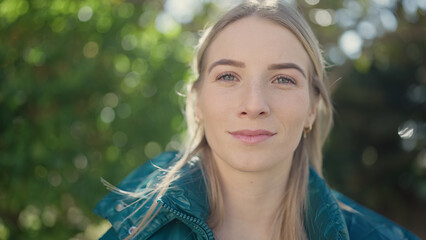 Poster - Young blonde woman standing with serious expression at park