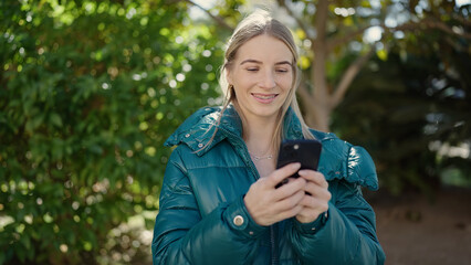 Poster - Young blonde woman using smartphone at park