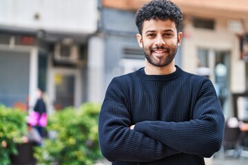 Sticker - Young arab man smiling confident standing with arms crossed gesture at street