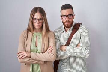 Wall Mural - Young couple standing over white background skeptic and nervous, disapproving expression on face with crossed arms. negative person.