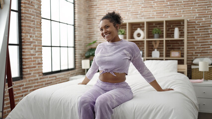 Poster - African american woman smiling confident sitting on bed at bedroom