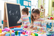 © Krakenimages.com - Two kids playing with maths puzzle game standing at kindergarten
