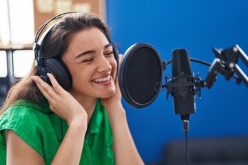 Wall Mural - Young hispanic woman artist singing song at music studio