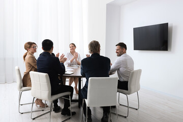 Canvas Print - Business conference. Group of people watching presentation on tv screen in meeting room