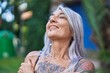 © Krakenimages.com - Middle age grey-haired woman breathing with closed eyes at park