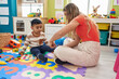 © Krakenimages.com - Teacher and toddler tying shoe at kindergarten