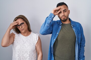 Poster - Hispanic mother and son standing together worried and stressed about a problem with hand on forehead, nervous and anxious for crisis