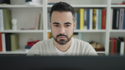 Sticker - Young hispanic man student using computer studying at library university