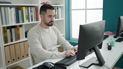 Sticker - Young hispanic man student using computer studying at library university