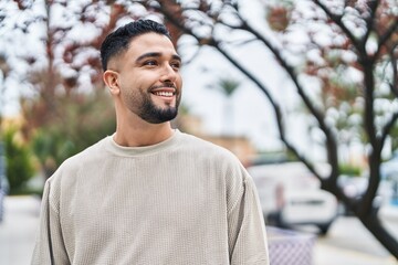 Wall Mural - Young arab man smiling confident standing at park