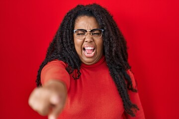 Canvas Print - Plus size hispanic woman standing over red background pointing displeased and frustrated to the camera, angry and furious with you