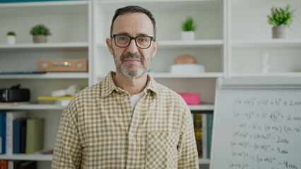 Wall Mural - Middle age man teacher standing with serious expression at classroom