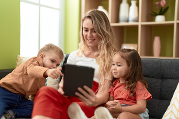 Sticker - Woman with girl and boy using touchpad sitting on sofa at home