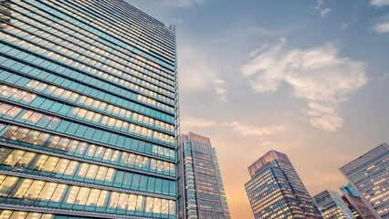 Wall Mural - Twilight sky time lapse view looking up at modern office building. Business, corporate and finance concept.