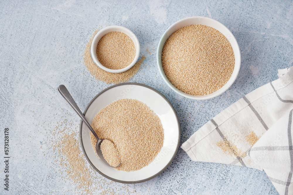 Bowls of amaranth seeds on light background