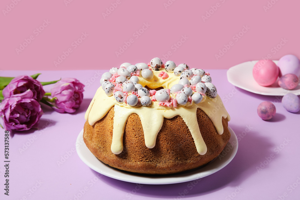 Plate with tasty Easter cake, eggs and tulip flowers on color background