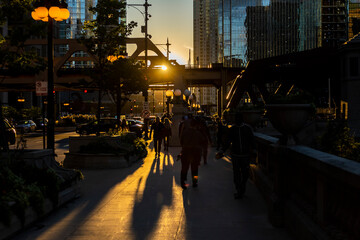 Chicago, IL USA September 21st 2022:  people are walking the streets of downtown during Chicago henge 2022. the epic sunset turned the town bright orange.