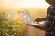 Farmer using digital tablet in corn crop cultivated field with smart farming interface icons and light flare sunset effect. Smart and new technology for agriculture business concept.