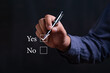 © Bordinthorn - Businessman holding pen and check Yes or No icon. Idea for about choices the good or bad way for business.