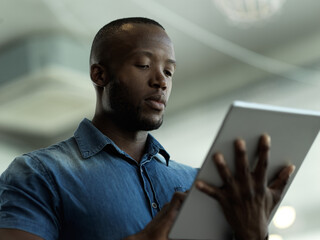 Fototapete - Technology, communication and black man with tablet reading email, sales news or global networking. Research, company leader with vision and online administration in b2b management at startup office.