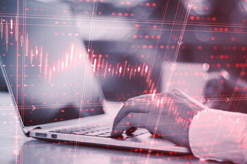Poster - Crisis and financial downturn concept with digital red glowing financial chart candlestick on man hands typing on modern laptop background, double exposure