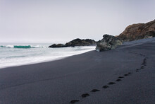 Footsteps In Black Sand