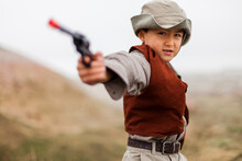 Boy wearing explorer costume holding pistol toy