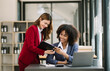 © Nuttapong punna - Two businesswoman discuss investment project working and planning strategy with tablet laptop computer in modern office..
