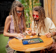 Hippie style couple examines joints and buds of medical marijuana.