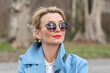 © Anelo - portrait of a stylish blonde 40-45 years old with glasses on a blurry background of nature.