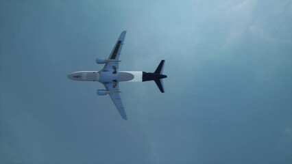 Wall Mural - Passenger plane flying overhead. View from below of the flying plane. Video 4k